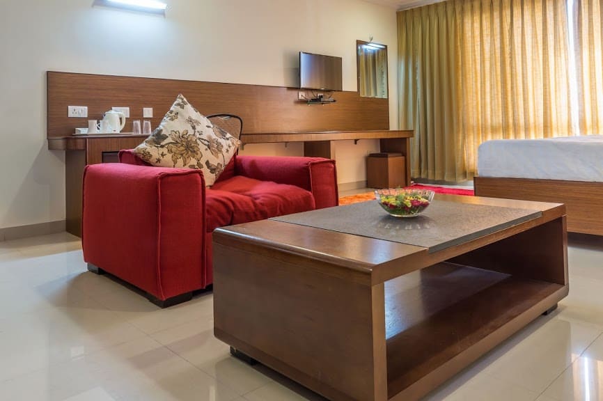 Deluxe room bed at Hotel Saptagiri